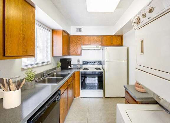 A kitchen with a white oven and black countertops at The Waverly on the Lake - Belleville, MI Apartment , Michigan, 95050