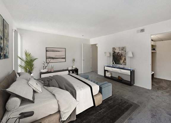 A bedroom with a bed, nightstand, and a plant at The Waverly on the Lake - Belleville, MI Apartment , Belleville, Michigan