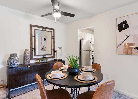 A dining room with a table set for two and a ceiling fan at The Waverly on the Lake - Belleville, MI Apartment , Belleville, MI