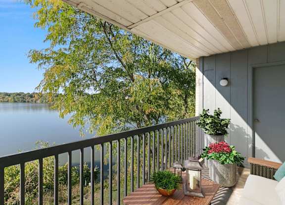 A balcony with a view of a lake and trees at The Waverly on the Lake - Belleville, MI Apartment , Belleville, 95050