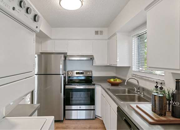 A modern kitchen with stainless steel appliances and white cabinets at The Waverly on the Lake - Belleville, MI Apartment , Belleville