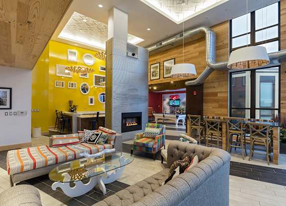 A modern living room with a fireplace and a grey couch.