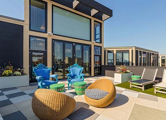 A modern outdoor seating area with a black and white checkered floor.