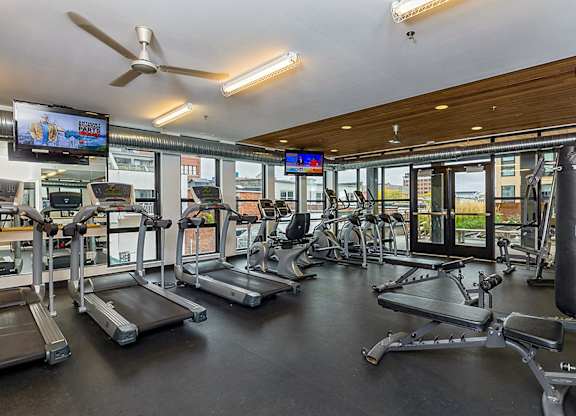 A gym with treadmills, a punching bag, and a television.