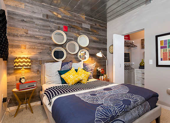 A bedroom with a bed, a nightstand, and a lamp.