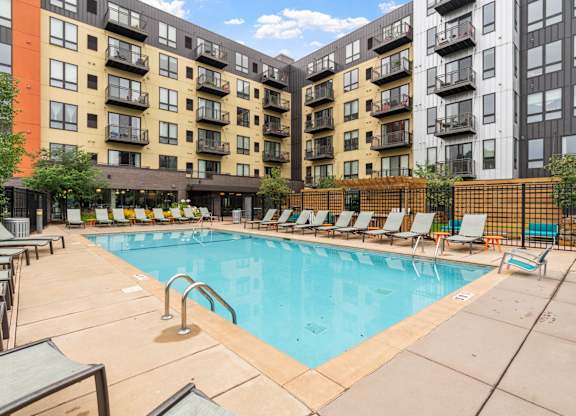 our apartments have a large swimming pool with lounge chairs at Be @ Axon Green, Minnesota, 55416