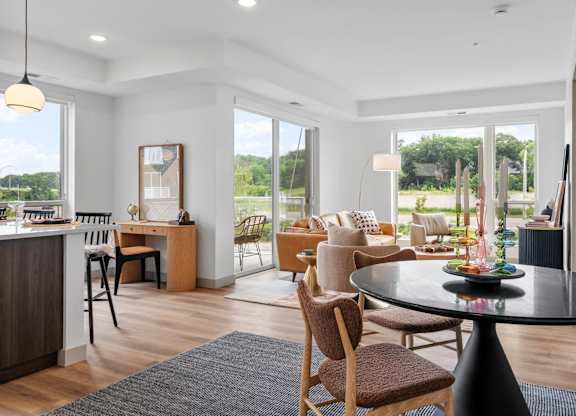 a living room and dining room with a table and chairs at The Mera, St Louis Park, Minnesota