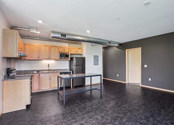 A kitchen with a table and chairs in the middle of the room.