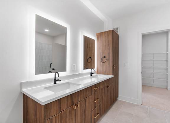 A bathroom with a double sink vanity and a large mirror.