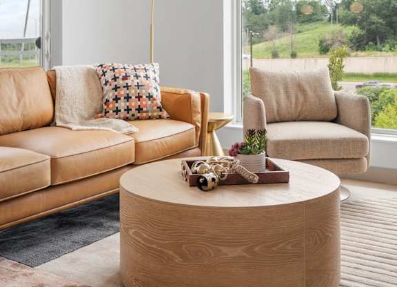 a living room with couches and a coffee table and a large window at The Mera, Minnesota 55426