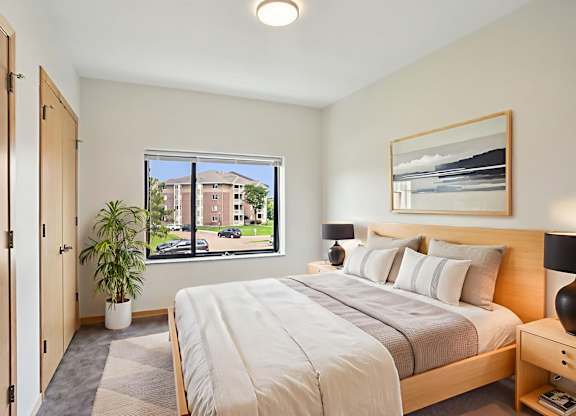 A bedroom with a large bed and a window overlooking a street.