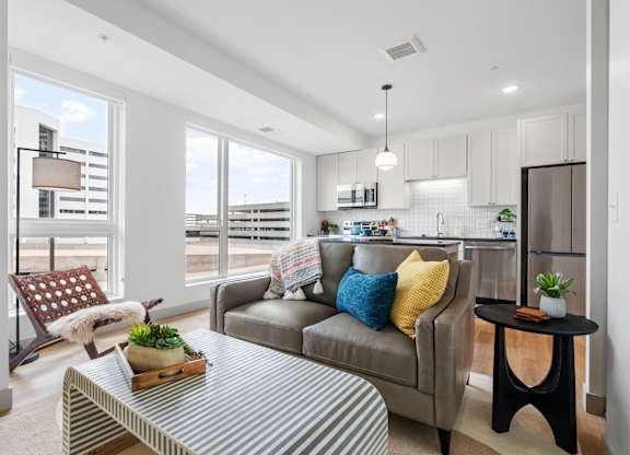 A modern living room with a grey couch and a striped coffee table. at The Mera, St Louis Park, MN, 55426