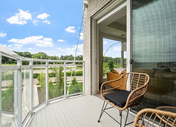 a balcony with a wicker chair and a view of the outdoors at The Mera, St Louis Park