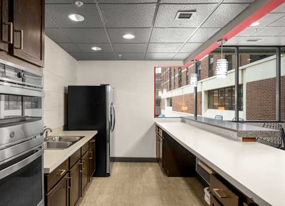 A modern kitchen with a black refrigerator and stainless steel appliances.