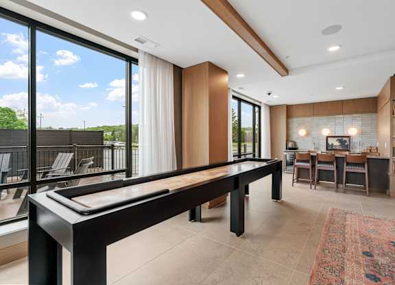 The billiards table and shuffleboard game in the Game Lounge, a reservable community room at Lilia in Lilydale, MN 55118