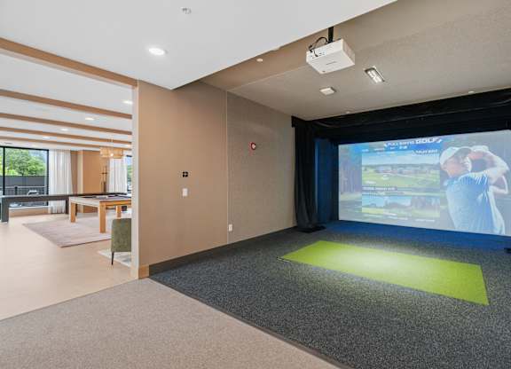 The Game and Golf Simulator with seating in the Game Lounge, a reservable community room at Lilia in Lilydale, MN 55118