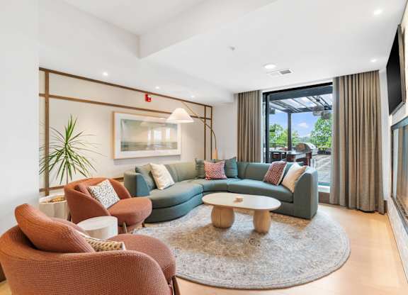 Comfortable seating across from the fireplace in the Clubroom, a reservable community room at Lilia in Lilydale, MN 55118
