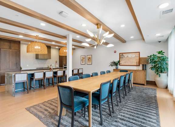 The long dining table and oversized kitchen in the Private Dining Room, a reservable community room at Lilia in Lilydale, MN 55118