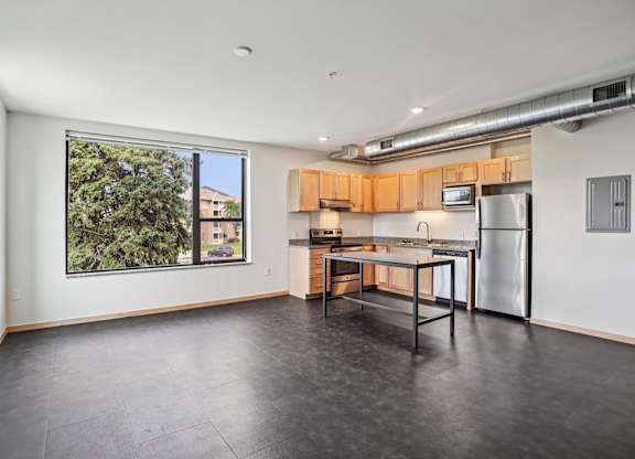 A kitchen with a table and chairs in front of a window.