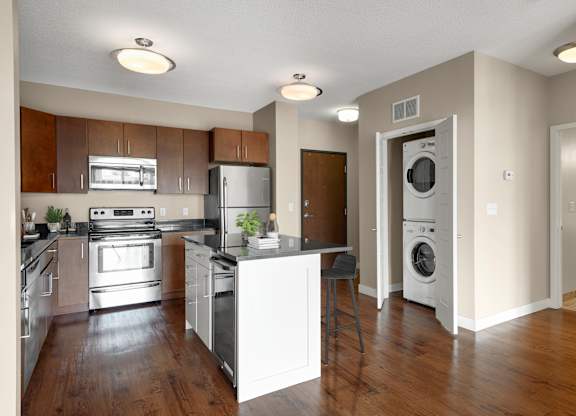 a kitchen with an island and a washer and dryer at Be @ Axon Green, Minneapolis, MN