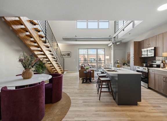 The Ellory Model Home. A modern kitchen with a dining table and chairs.