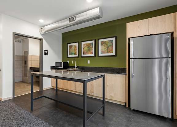 A kitchen with a refrigerator, stove, and table.