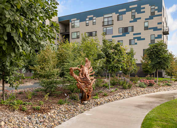 A zebra sculpture is in the middle of a garden.