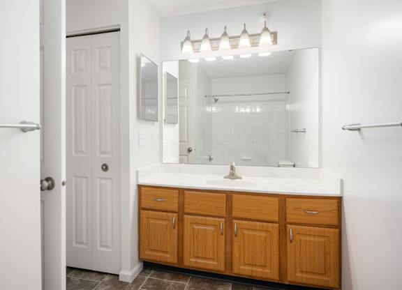 a bathroom with a sink and a mirror and a shower at Cityscape, St Louis Park, MN, 55416