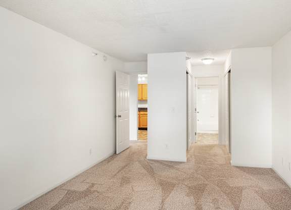 a spacious living room with white walls and a carpeted floor at Cityscape, St Louis Park, 55416