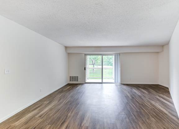 the spacious living room with wood flooring and a sliding glass door at Cityscape, St Louis Park, MN, 55416