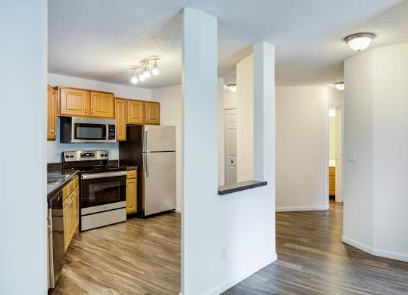 a renovated kitchen with wood flooring and stainless steel appliances at Cityscape, St Louis Park, MN