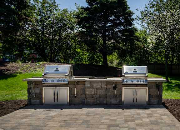 a stone outdoor kitchen with two gas grills at Cityscape, St Louis Park, 55416