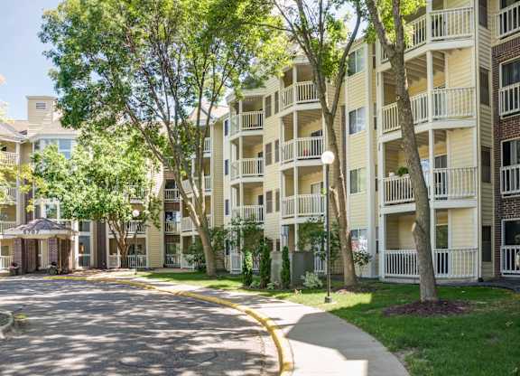 a street view of an apartment building with trees and a sidewalk at Cityscape, Minnesota, 55416
