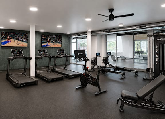A gym with treadmills, exercise bikes, and other equipment.