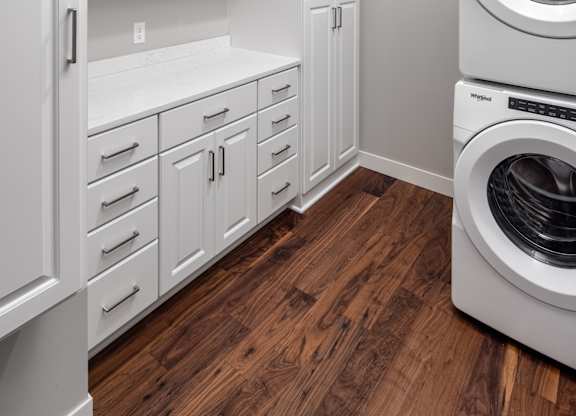 a laundry room with a washer and dryer and white cabinets at Expo, Minnesota, 55414
