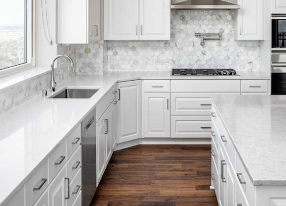 a white kitchen with marble counter tops and white cabinets at Expo, Minneapolis