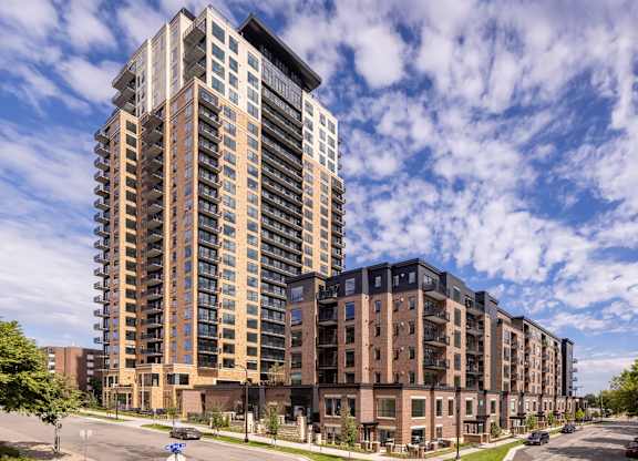 a tall apartment building on a city street under a cloudy sky at Expo, Minneapolis