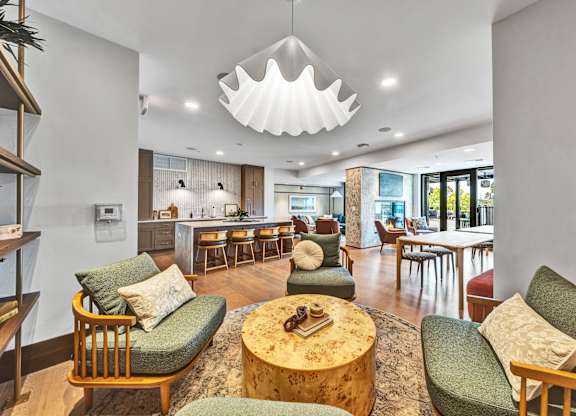 A living room with a green chair and a wooden coffee table.at Lilia, Lilydale, MN, 55118