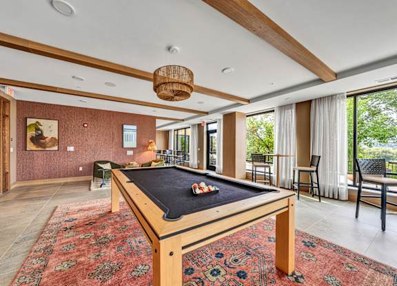 A pool table in a room with a view of trees outside the window.at Lilia, Lilydale, MN