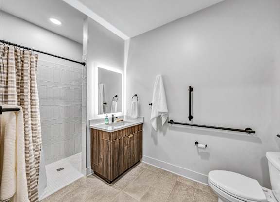 A bathroom with a toilet, sink, and shower.at Lilia, Lilydale, MN, 55118