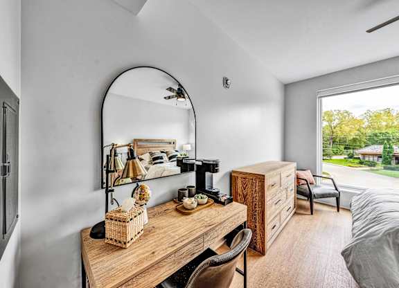 A room with a wooden desk and a mirror on the wall.at Lilia, Lilydale, MN