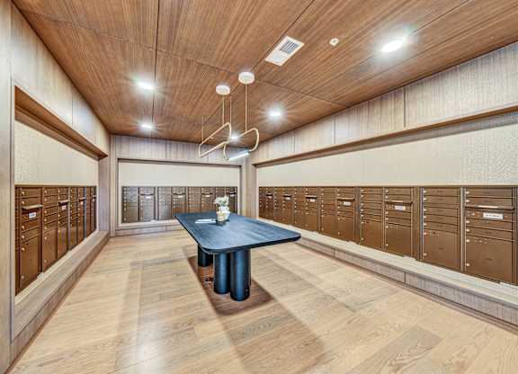 A room with wooden walls and ceiling, a table in the middle, and a row of lockers on the wall.at Lilia, Lilydale, MN, 55118