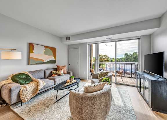 A living room with a grey couch and a large painting on the wall. at Lilia, Minnesota