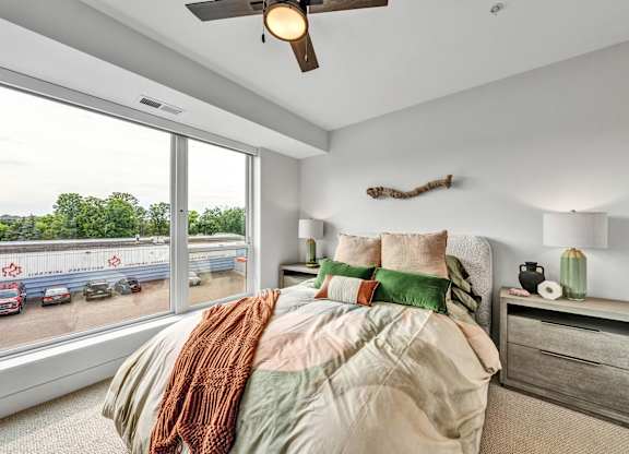 A bedroom with a large bed and a ceiling fan.at Lilia, Lilydale, MN