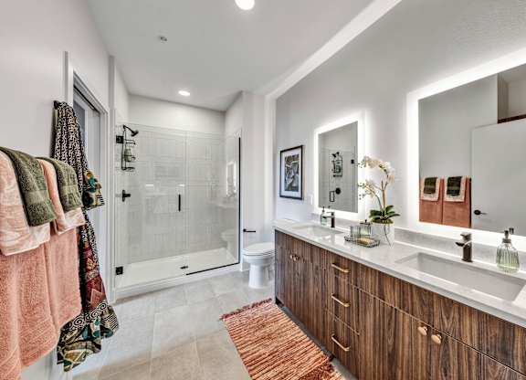 A bathroom with a white sink, a mirror, a toilet, and a shower.at Lilia, Lilydale, Minnesota