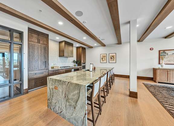 A kitchen with a marble island and wooden floors.at Lilia, Lilydale, MN, 55118