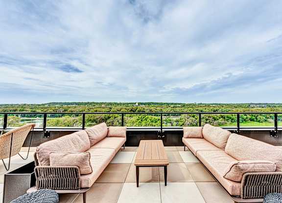 A patio with a couch, chairs, and a table overlooking a green landscape.at Lilia, Lilydale