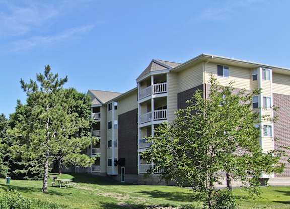 an apartment building on a hill with trees at Cityscape, St Louis Park, MN, 55416