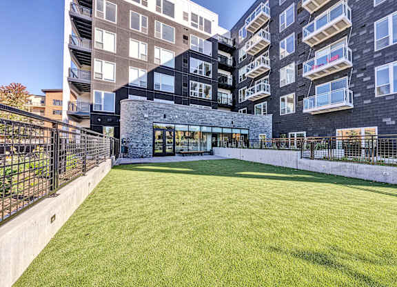 A large grassy area in front of a modern building. at The Mera, Minnesota