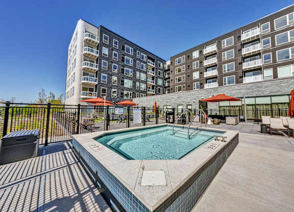 A swimming pool surrounded by a fence and chairs. at The Mera, Minnesota, 55426